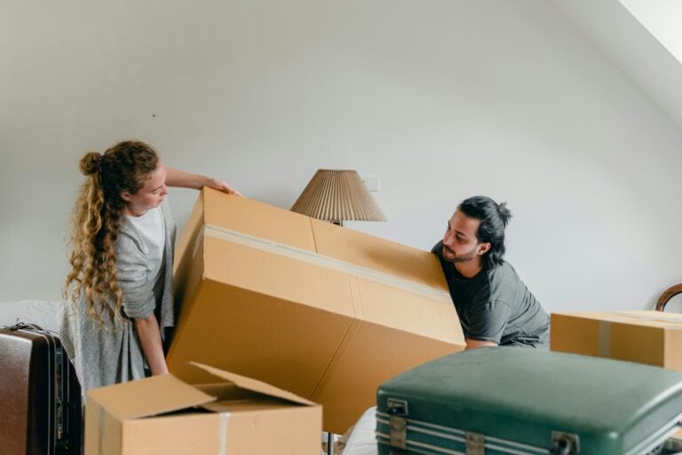 A couple is lifting carton in the concept of moving to Hendon