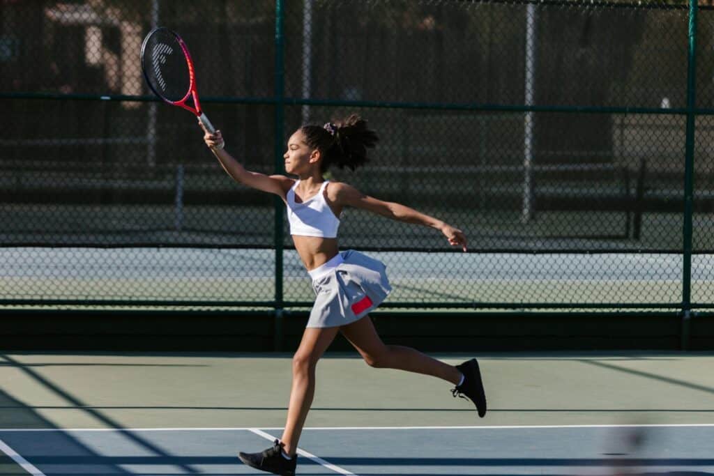 A girl is playing tennis on the court