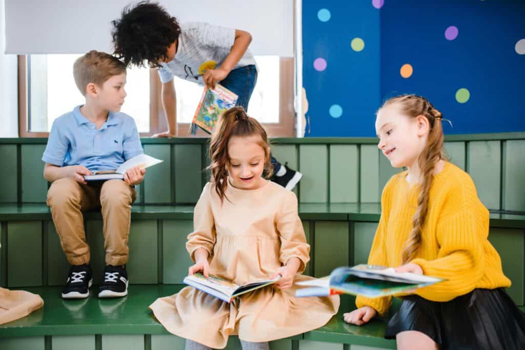 Young students holding books in the library in the concept of top schools in Hendon.