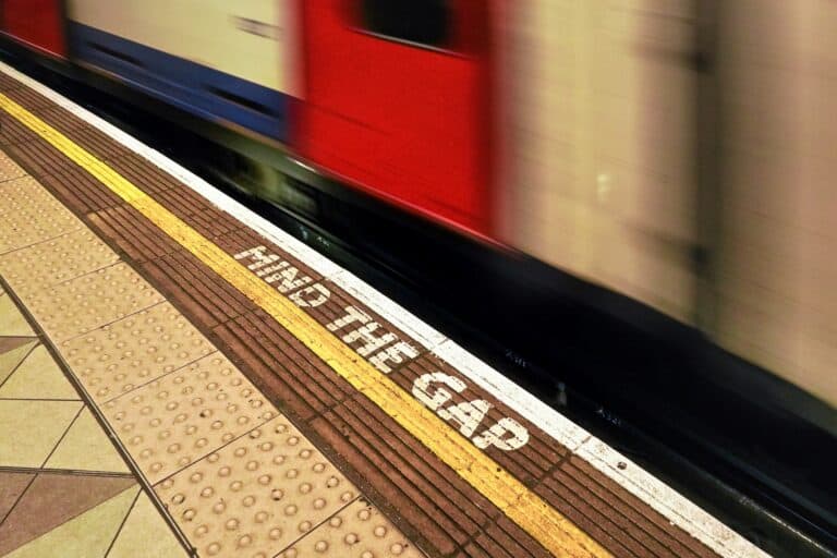 'Mind The Gap' text on the floor of a train station in London in the concept of 'how to use Hendon's public transport'.