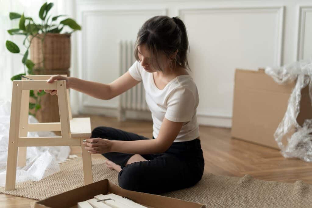 A woman re-assembling furniture after moving