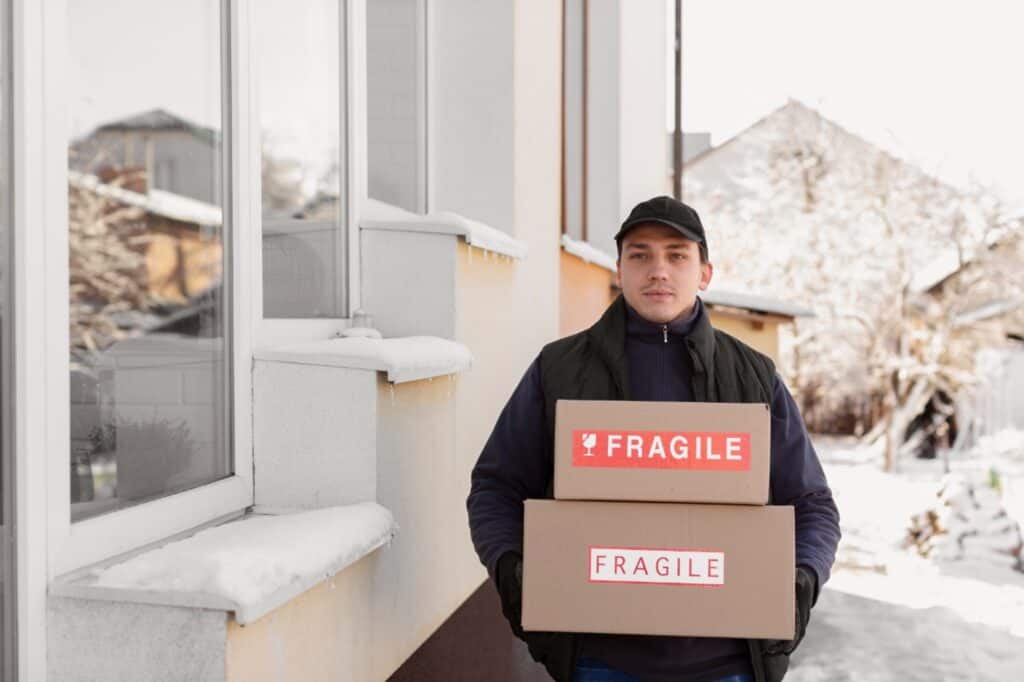 A man and van carrying boxes with fragile items one winter day