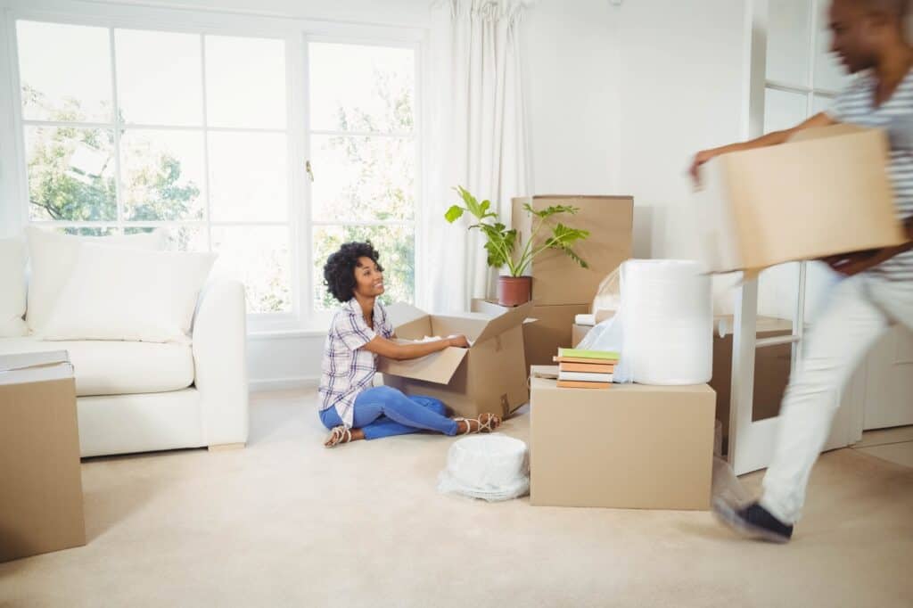 Happy couple packing for their house move in the concept of 'how to get a quote for a man and van service'.